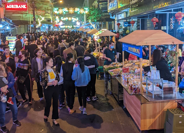 Crowds and street-food stalls at Kỳ Lừa night market under colourful lights
